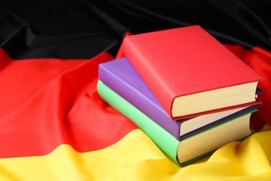 Photo of Learning foreign language. Different books on flag of Germany, space for text