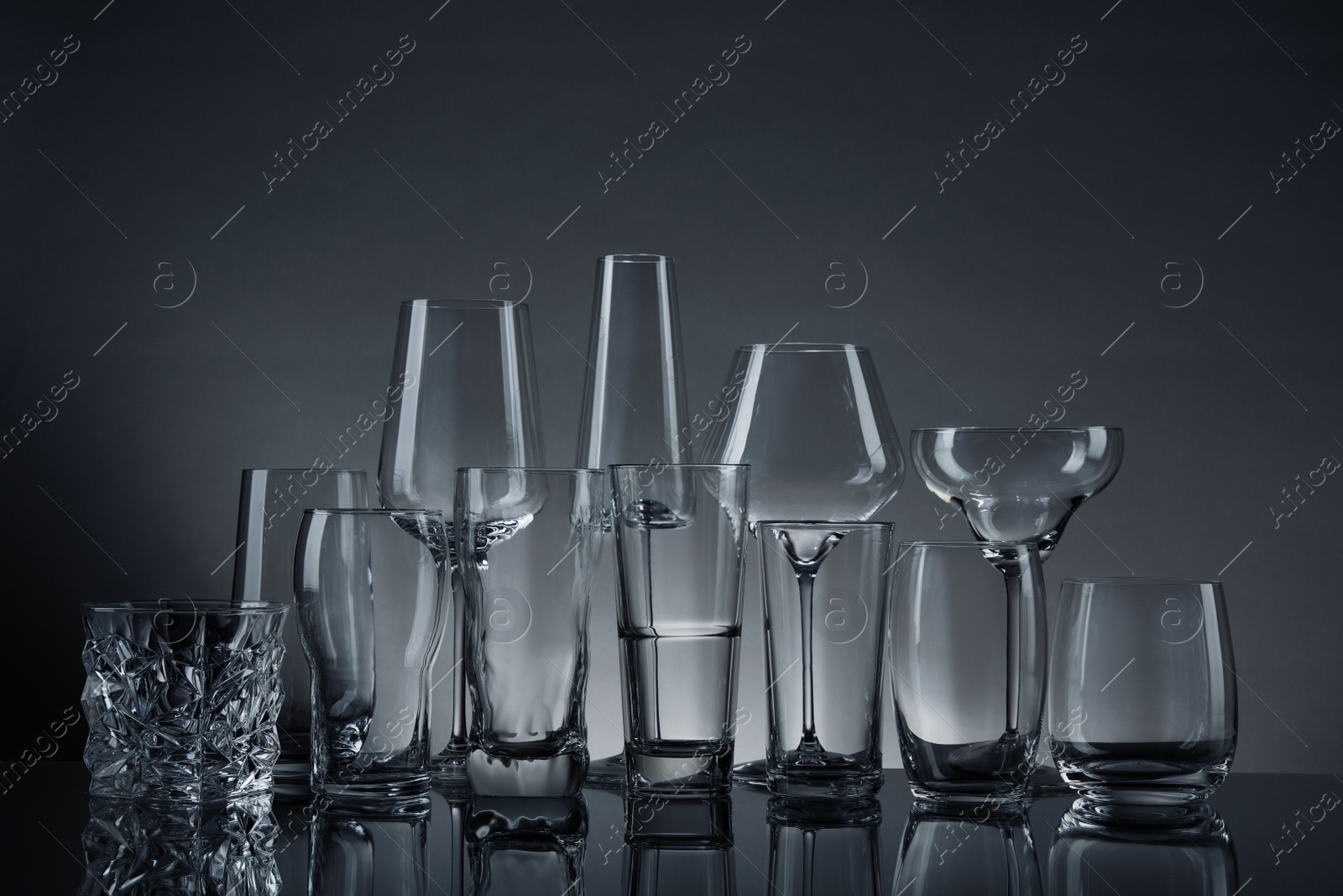 Photo of Set of empty glasses on table against grey background