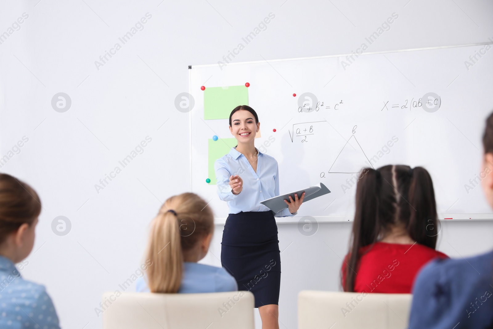Photo of Young teacher and students in modern classroom