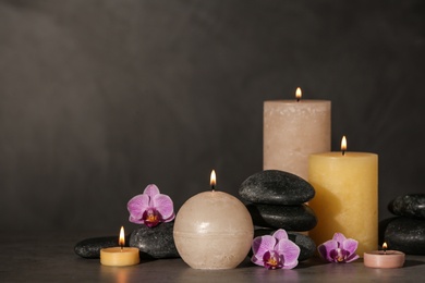 Composition with candles and spa stones on grey table. Space for text