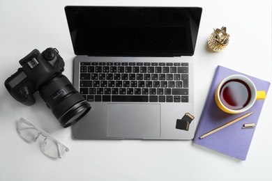 Photographer's workplace with laptop and camera on table, top view