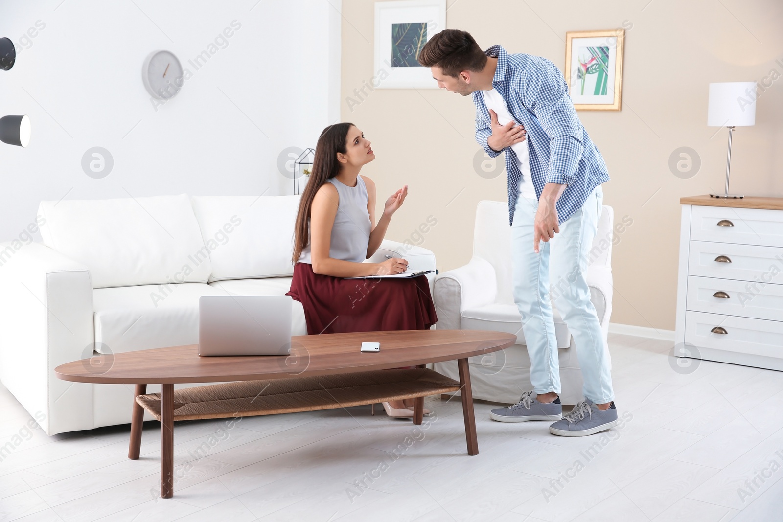 Photo of Depressed young man having appointment with psychologist in office