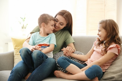 Photo of Young woman spending time with her children at home. Happy family