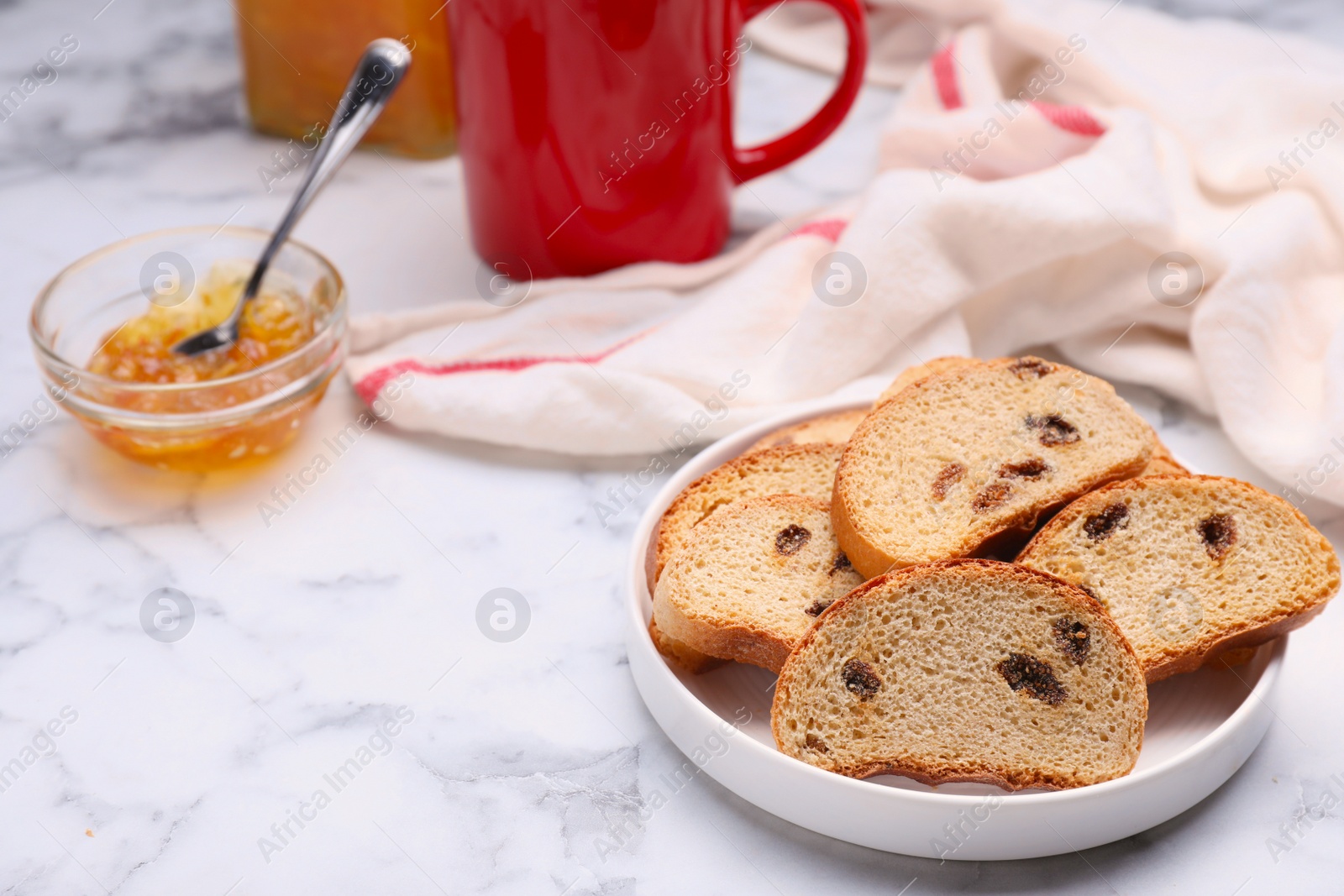 Photo of Sweet hard chuck crackers with raisins and jam on white marble table. Space for text