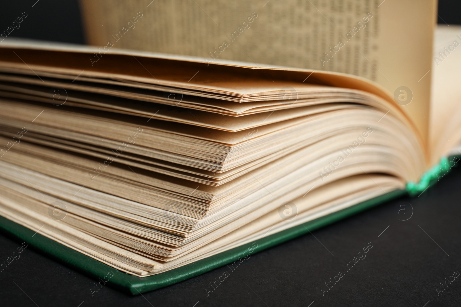 Photo of Closeup view of open book on black background