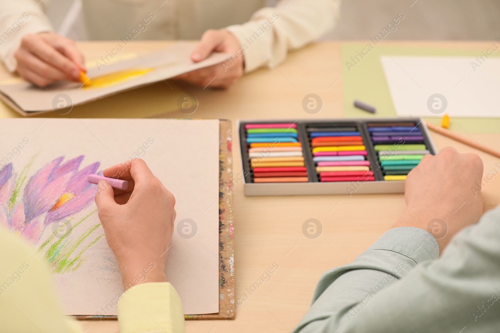 Photo of Artists drawing with soft pastels at table, closeup