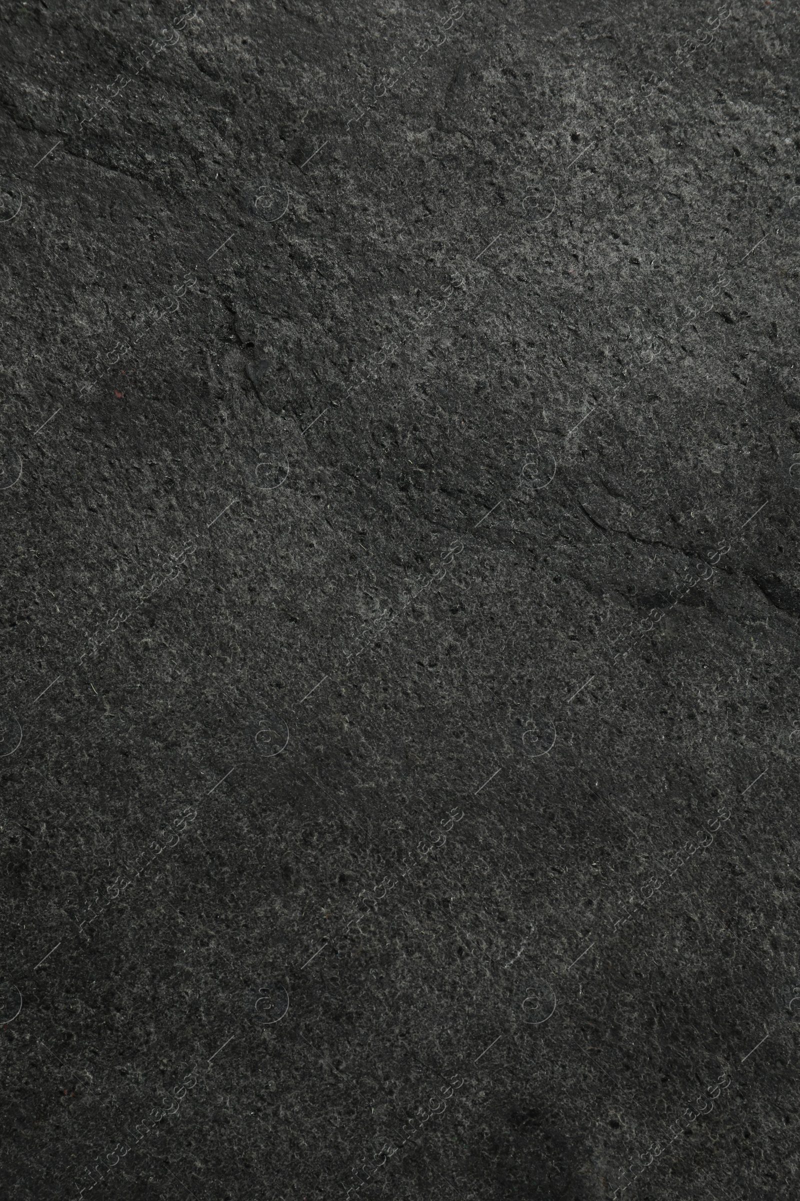 Photo of Texture of dark grey stone surface as background, closeup