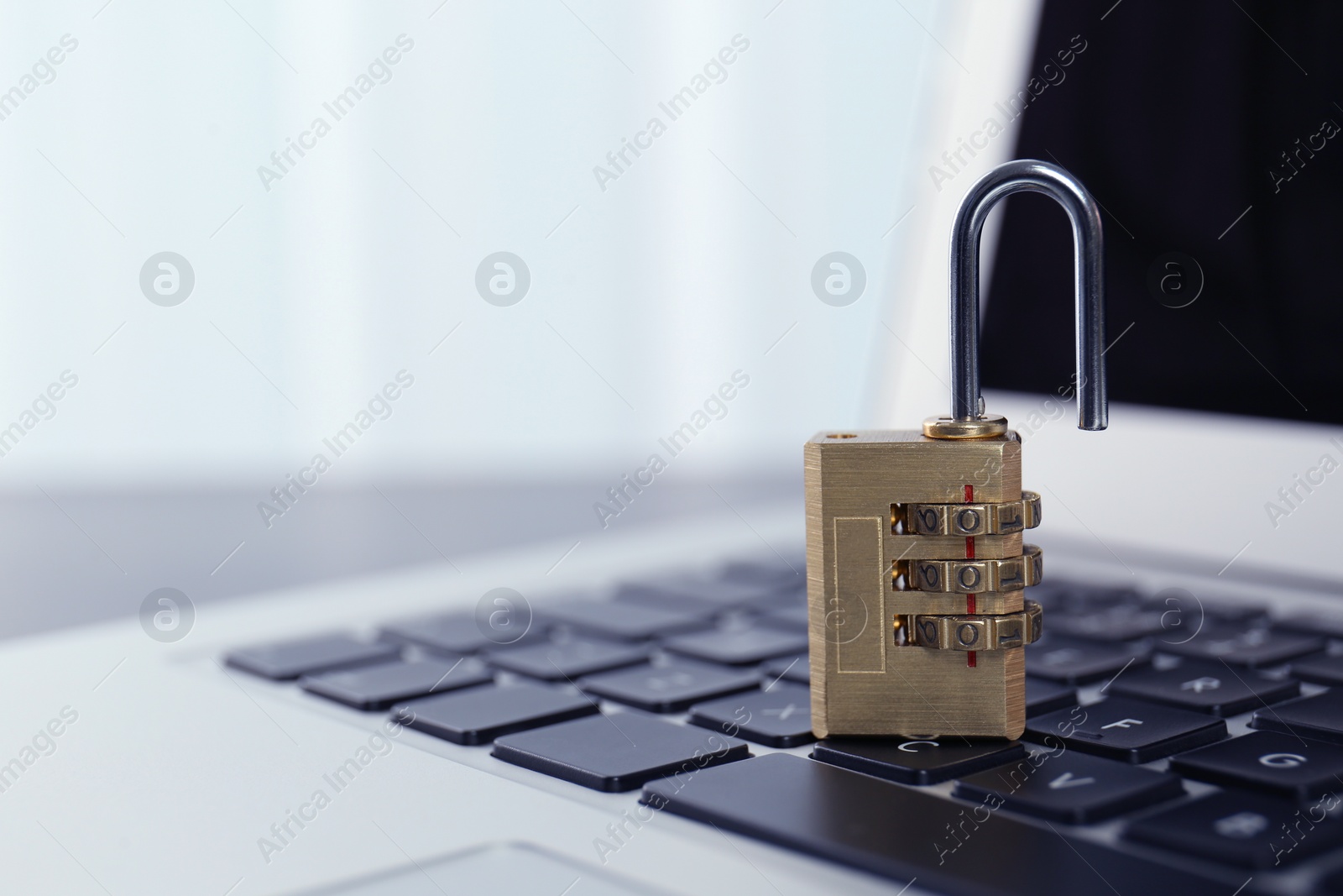 Photo of Metal code padlock on laptop keyboard, space for text. Cyber security concept