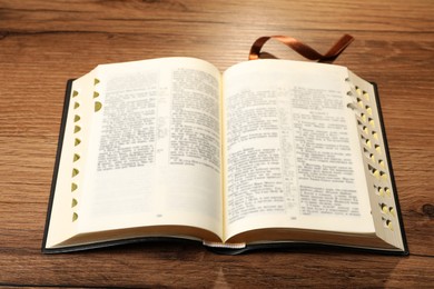 Photo of Open Bible on wooden table. Religious literature