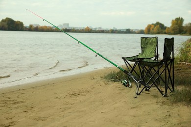 Folding chairs and fishing rod at riverside
