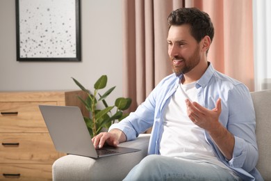 Photo of Man having video chat via laptop at home