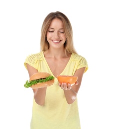 Photo of Young woman holding burger and grapefruit on white background. Choice between diet and unhealthy food