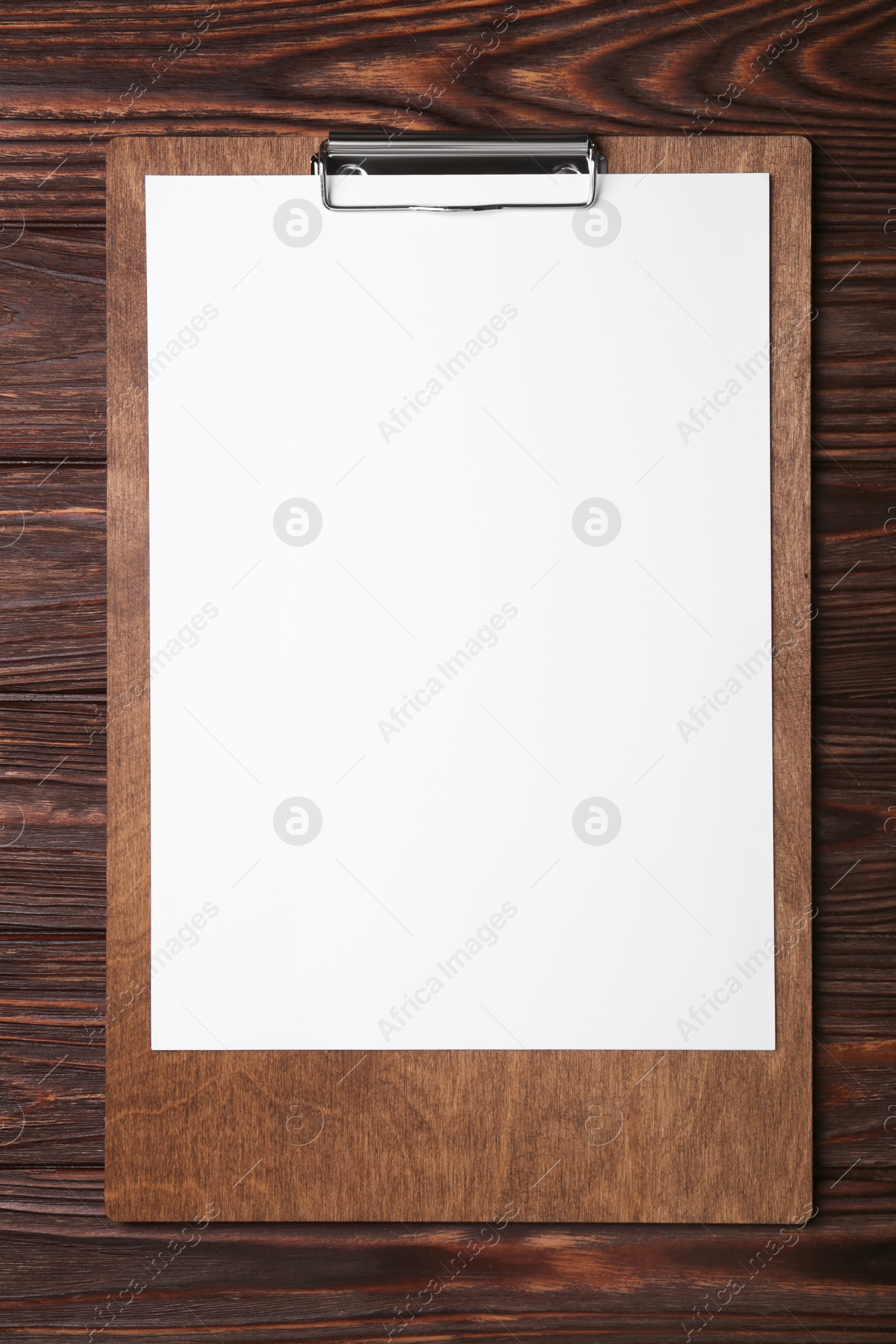 Photo of New clipboard with sheet of blank paper on wooden table, top view