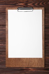 Photo of New clipboard with sheet of blank paper on wooden table, top view