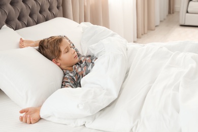 Cute tired boy sleeping in comfortable bed