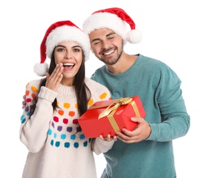 Photo of Young man giving gift box to his girlfriend on white background. Christmas celebration
