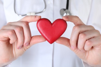 Doctor with red decorative heart, closeup view