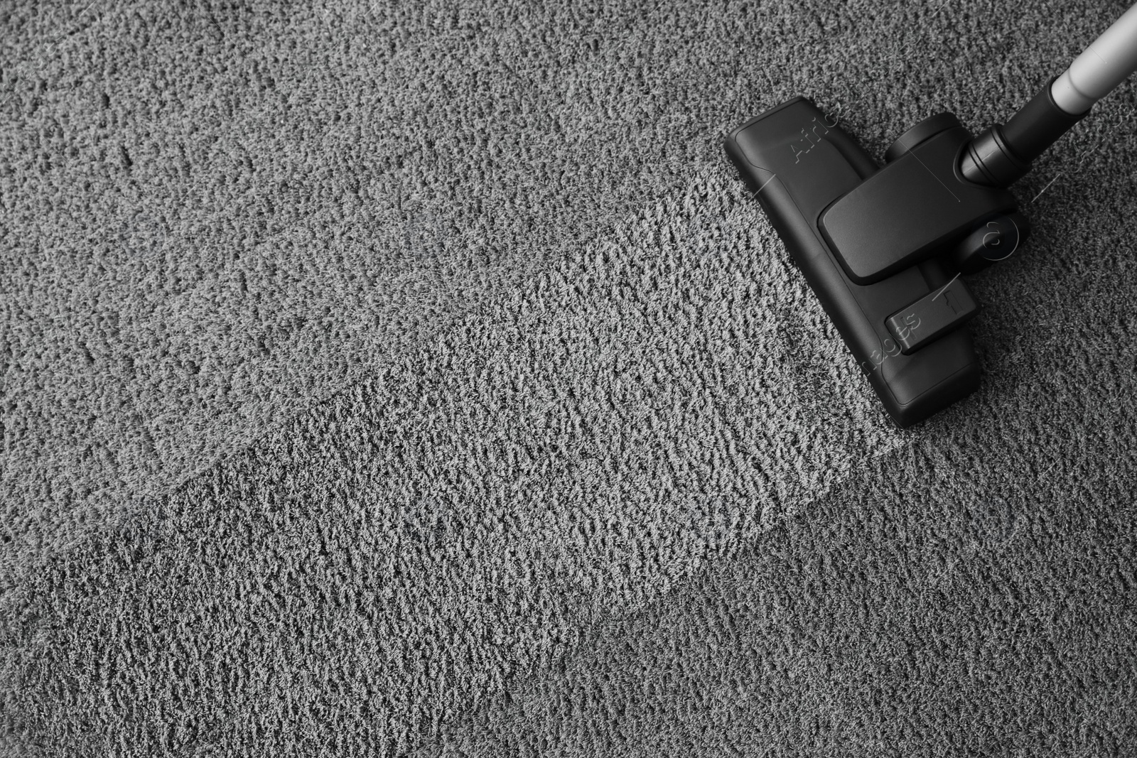 Photo of Modern vacuum cleaner on carpet, top view. Space for text