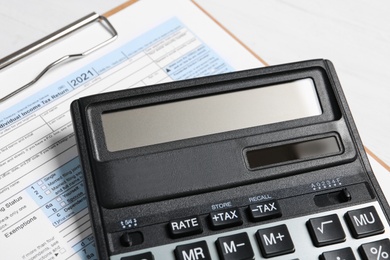 Photo of Calculator and document on white table, closeup. Tax accounting