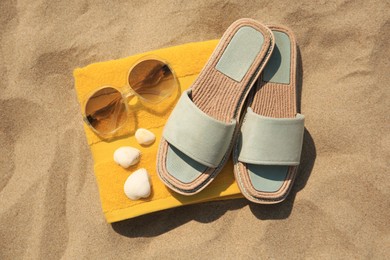 Beach accessories and seashells on sand, top view