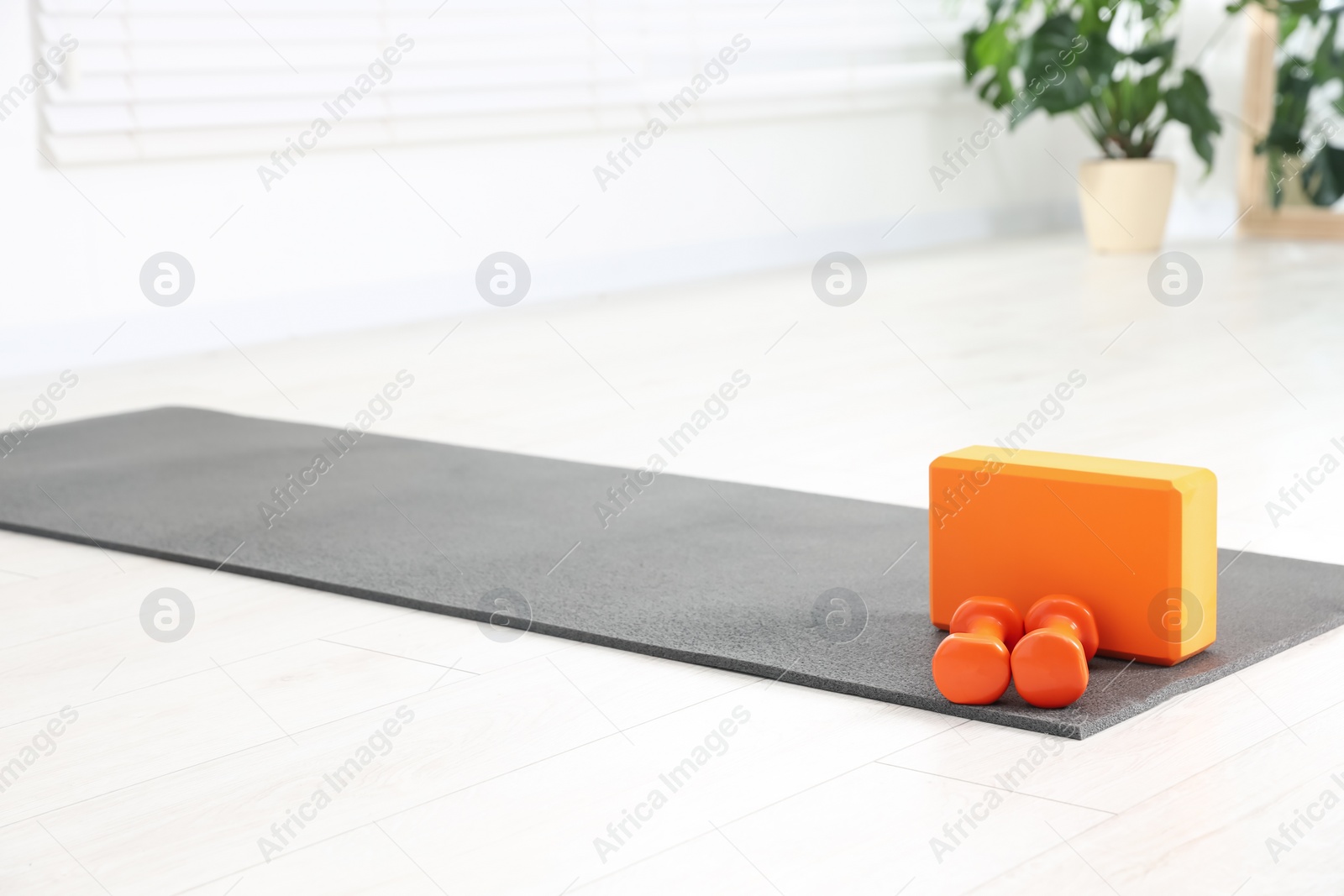 Photo of Exercise mat, yoga block and dumbbells at home