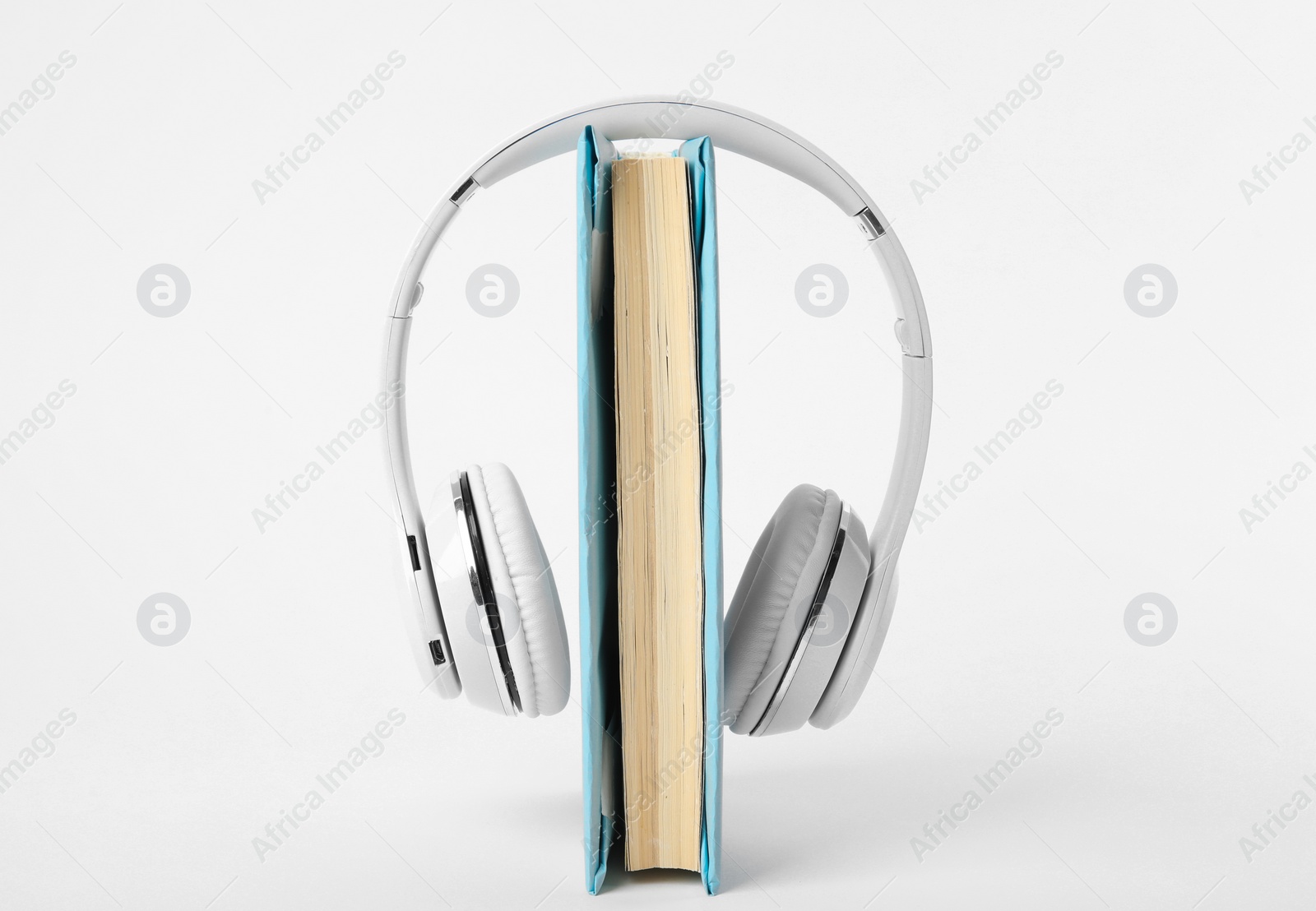 Photo of Book and modern headphones isolated on white