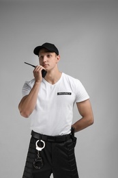 Photo of Male security guard using portable radio transmitter on color background