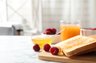 Photo of Delicious breakfast with toasted bread, honey and berries on white marble table indoors. Space for text