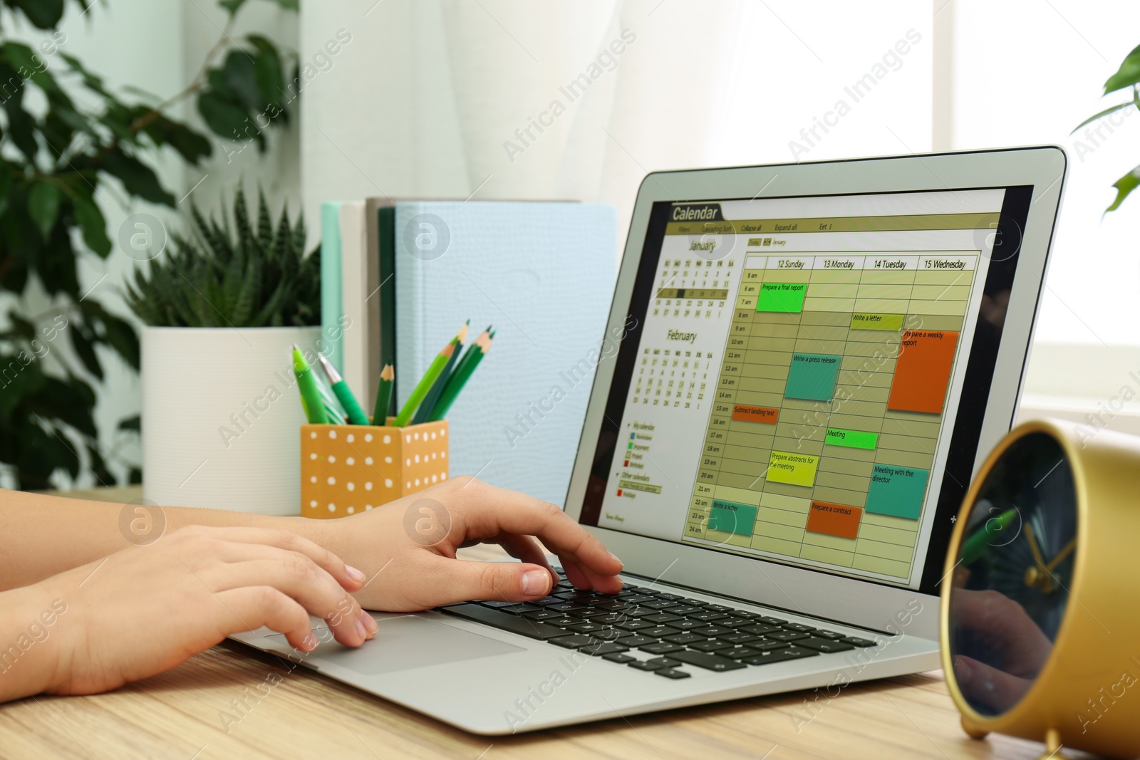 Photo of Woman using calendar app on laptop in office, closeup