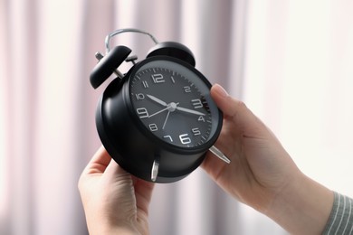 Photo of Woman with alarm clock indoors, closeup view
