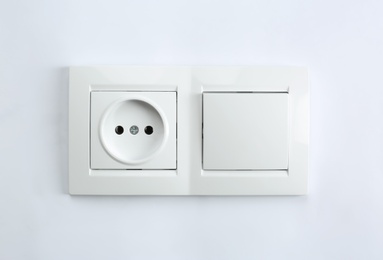 Light switch and power socket on white background. Electrician's equipment