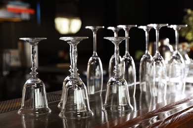 Photo of Different empty clean glasses on counter in bar