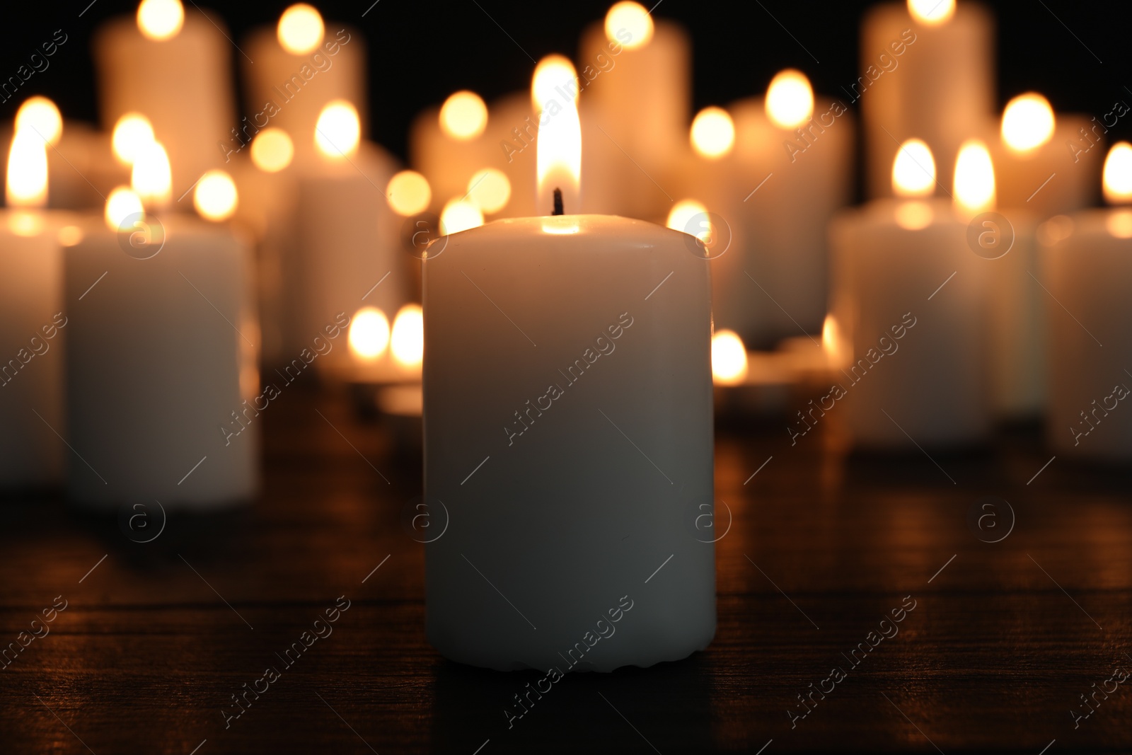 Photo of Burning candles on dark surface. Memory day