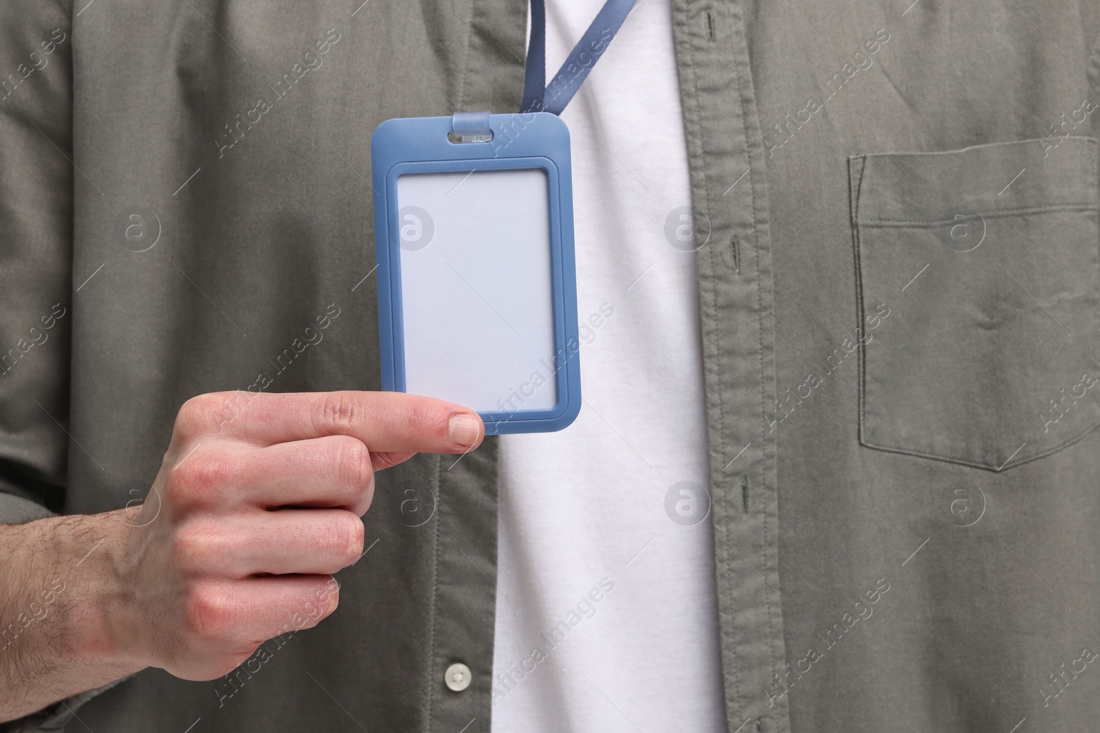 Photo of Man in shirt showing empty badge, closeup