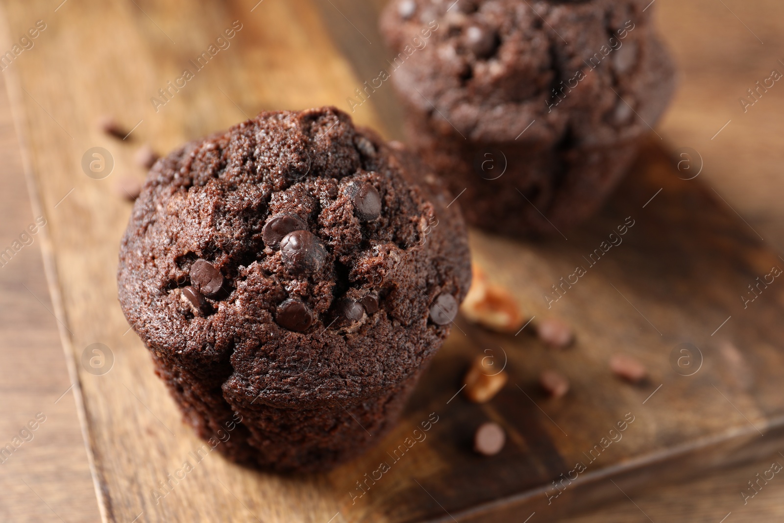 Photo of Delicious chocolate muffins on wooden table, closeup