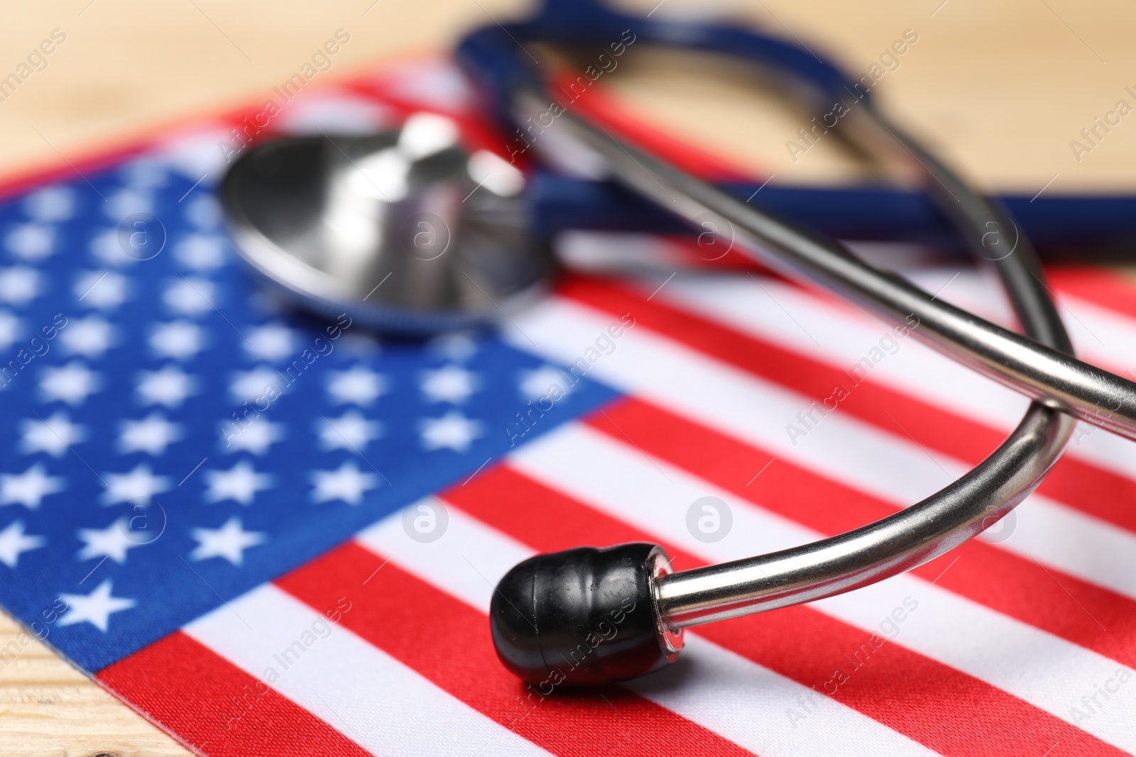 Photo of Stethoscope and USA flag on table, closeup. Health care concept