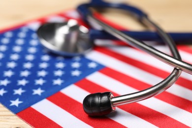 Photo of Stethoscope and USA flag on table, closeup. Health care concept