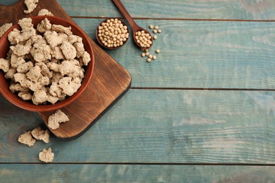 Photo of Dried soy meat and beans on light blue wooden table, flat lay. Space for text