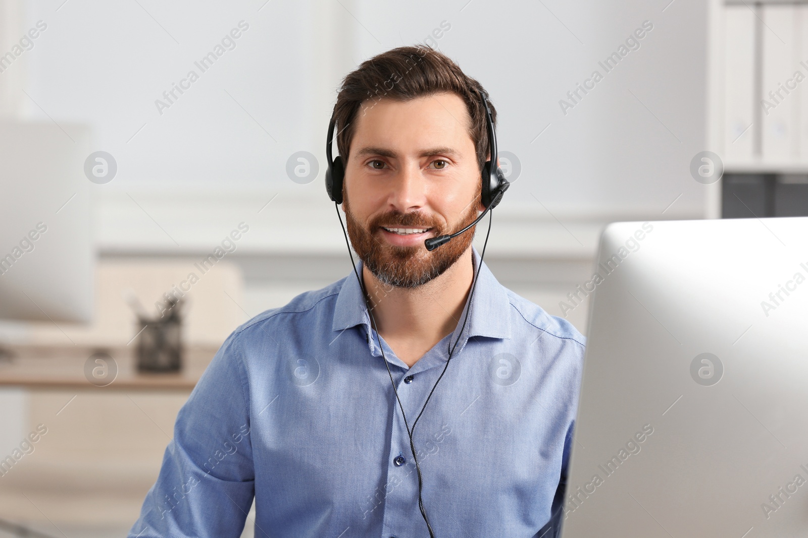 Photo of Hotline operator with headset working in office