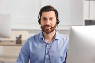 Photo of Hotline operator with headset working in office