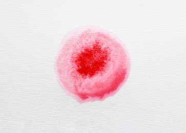 Photo of Blot of pink ink on white background, top view