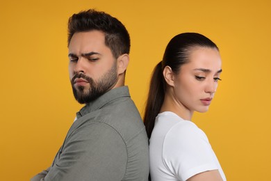 Portrait of resentful couple on orange background