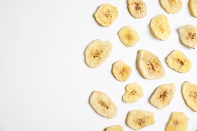 Flat lay composition with banana slices on  white background, space for text. Dried fruit as healthy snack