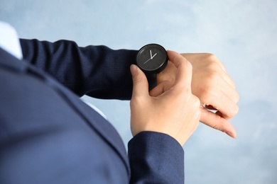 Photo of Businesswoman with stylish wrist watch on color background, closeup. Time management