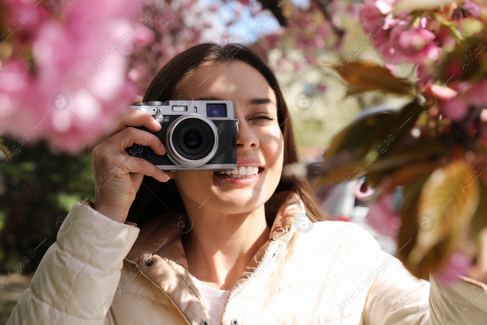 Photo of Happy female tourist taking photo of nature outdoors on spring day