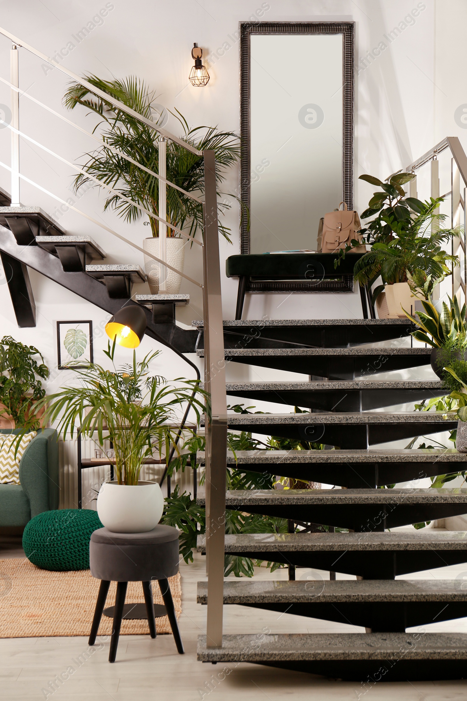 Photo of Stylish room interior with stairs and green plants