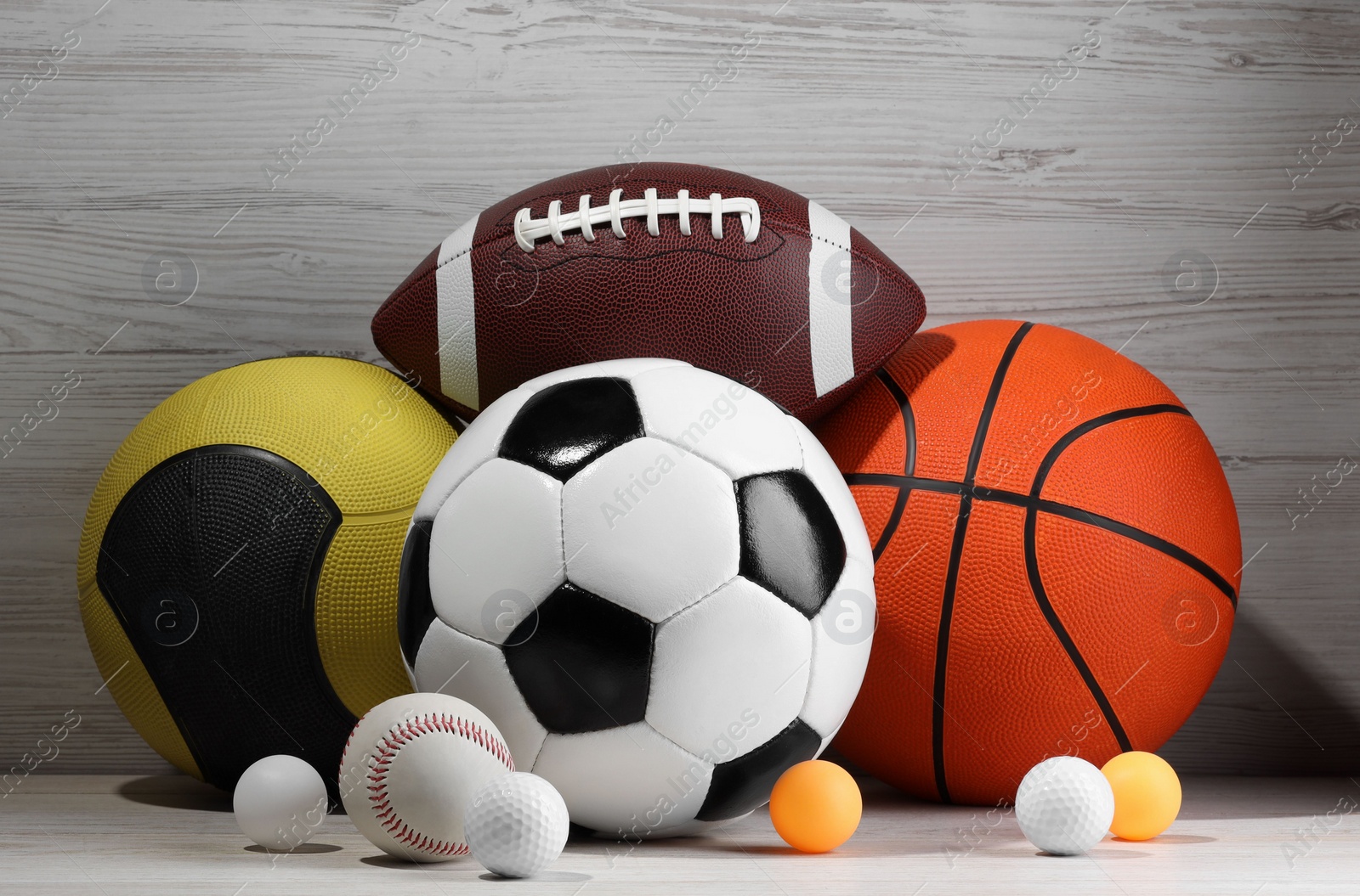 Photo of Many different sport balls on white wooden background