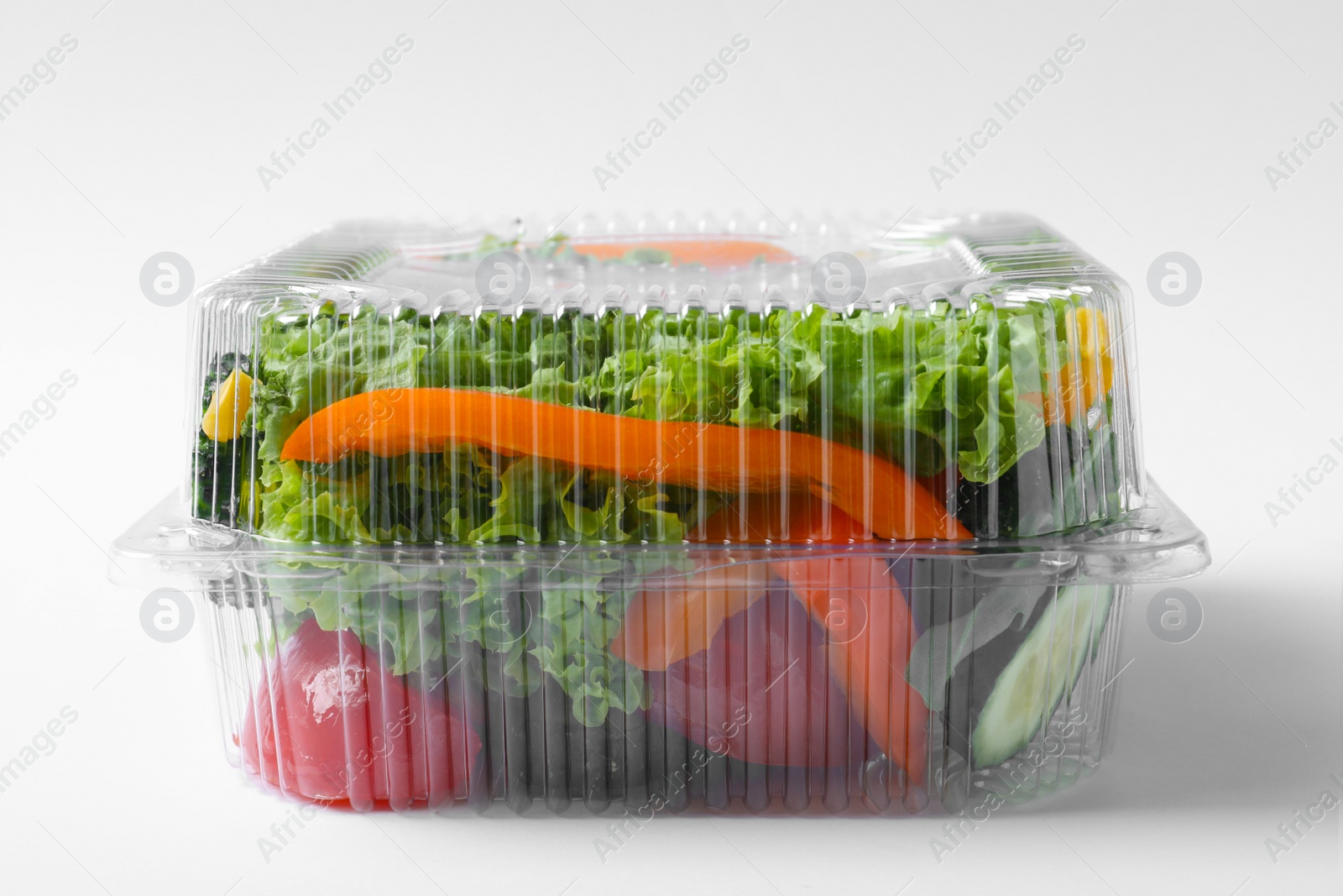 Photo of Plastic container with fresh salad on white background