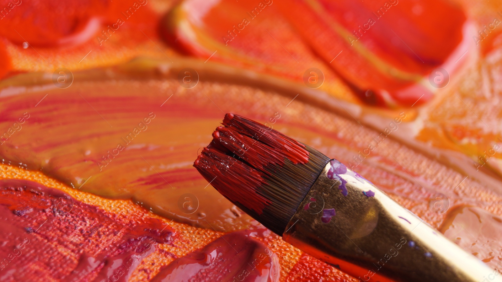 Photo of Brush on artist's palette with mixed paints, closeup