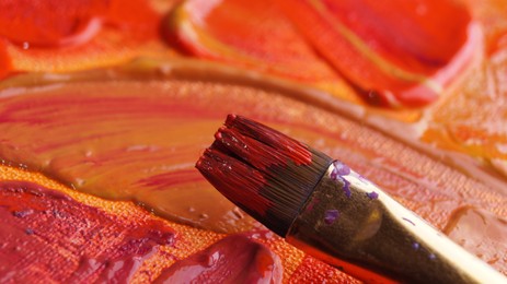 Photo of Brush on artist's palette with mixed paints, closeup